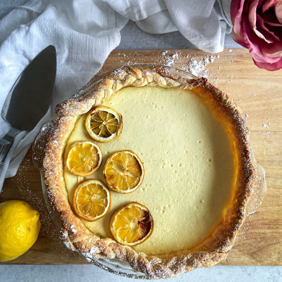 A photo of a lemon ricotta pie on a cutting board