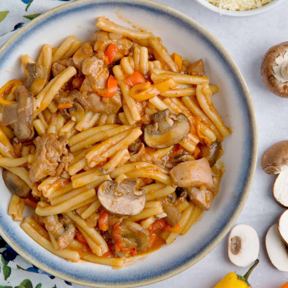 Chicken mushroom pasta served in a white and blue bowl.