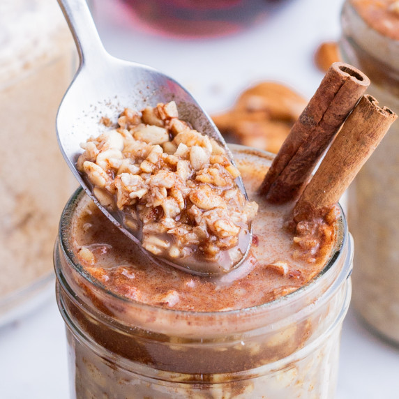 Maple Brown Sugar Overnight Oats RECIPE served in a mason jar with a spoon.