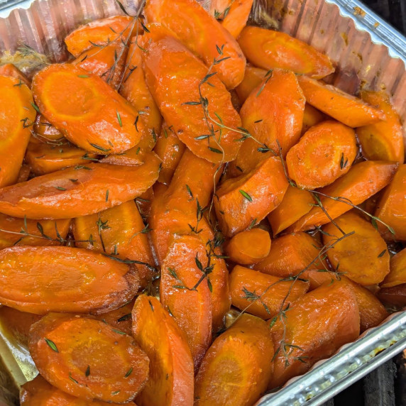 A pan of maple bourbon carrots sprinkled with fresh thyme. 