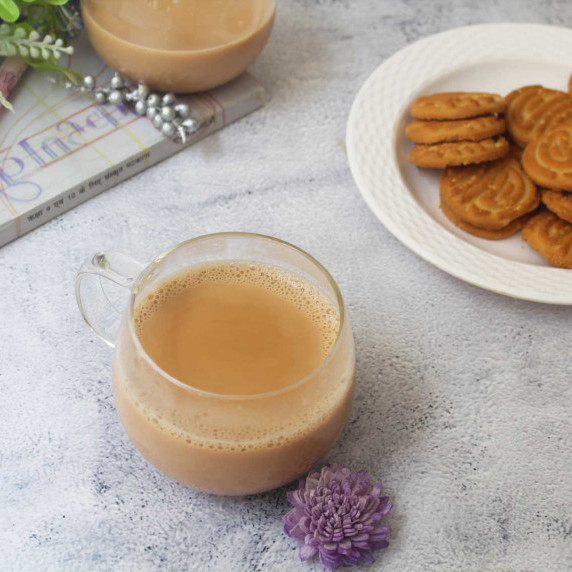 Steaming cup of Indian masala chai paired with delicious cookies. A perfect blend of flavors and com