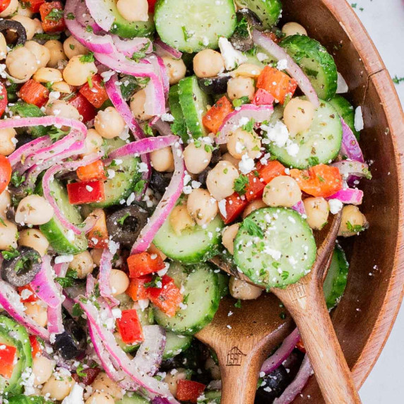 Mediterranean Chickpea Salad with Feta Cheese RECIPE served in a wooden bowl with a spoon.