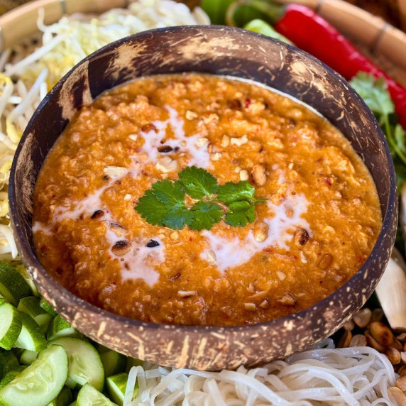 Mee ka tee, Thai red curry noodle soup, served in a coconut shell.