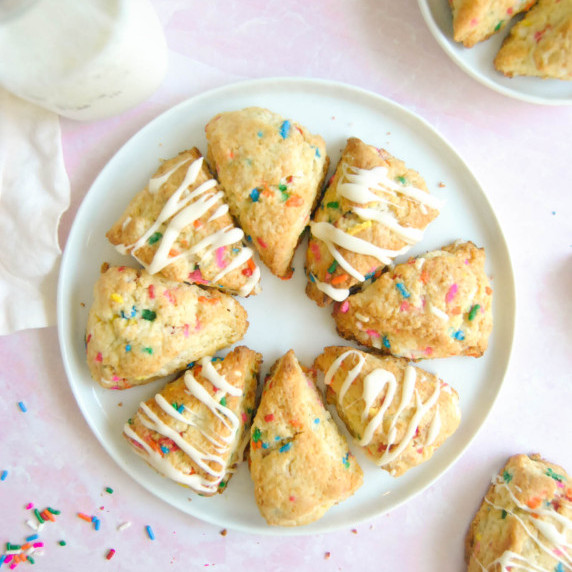 mini birthday cake scones on white plate with pink background