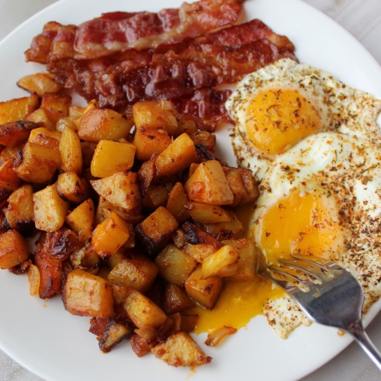 Home fries, sunny side up eggs, and crispy bacon