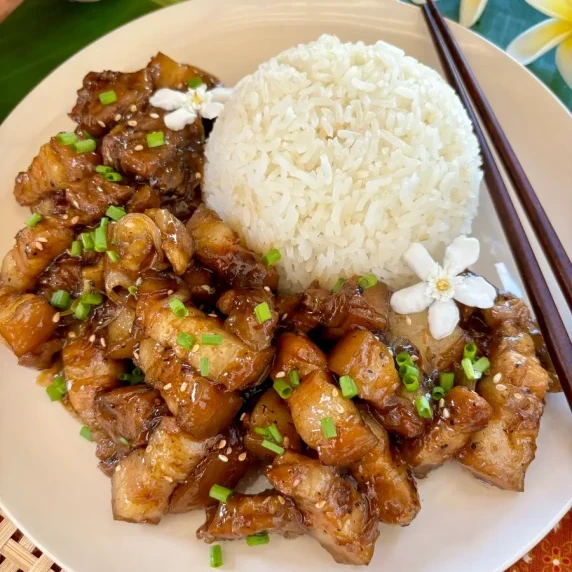 Top-view of Thai sweet pork garnished with green onions and a side of jasmine rice.