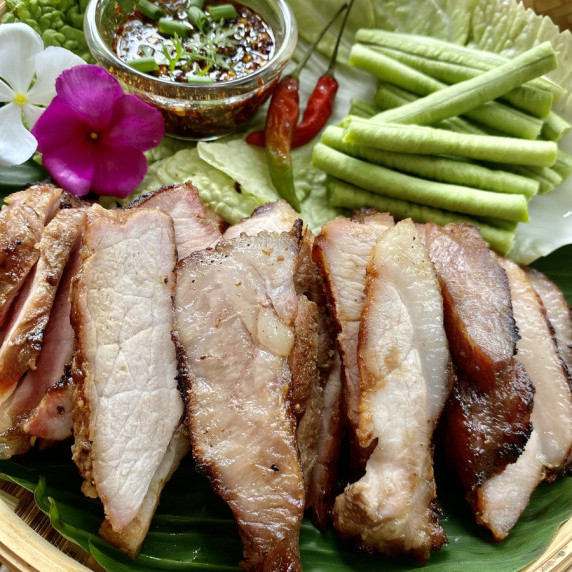 Moo yang, Thai grilled pork, served with a dipping sauce.