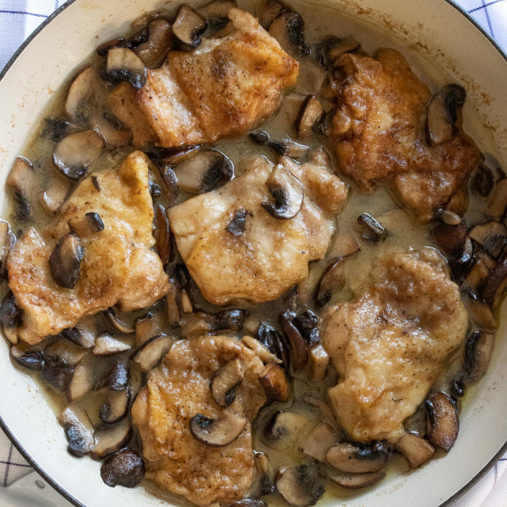 chicken thighs with mushrooms with a wine sauce in a large skillet