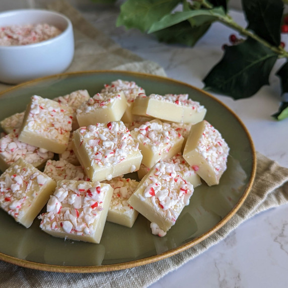 A plate of white chocolate peppermint fudge squares topped with crushed candy canes