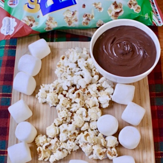 Popcorn gingerbread man with marshmallows on a Nutella Board.  