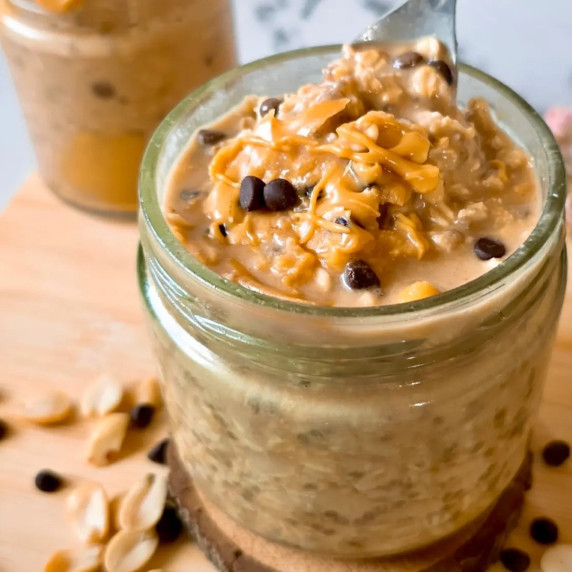 Overnight oats in a jar topped with chocolate chips and peanut butter.