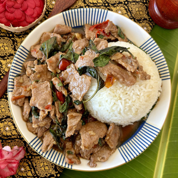 Top-view of pad horapa, a Thai sweet basil stir-fry with beef, served with rice.