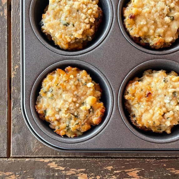 four Parmesan chicken muffins in a muffin tin.