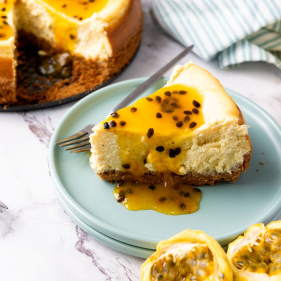 A slice of the passion fruit cheesecake in a plate on the counter