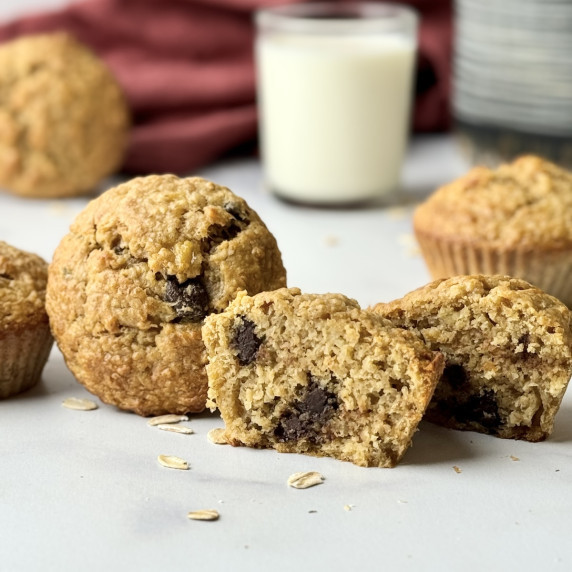 Peanut butter muffins on a table next to glass of milk.