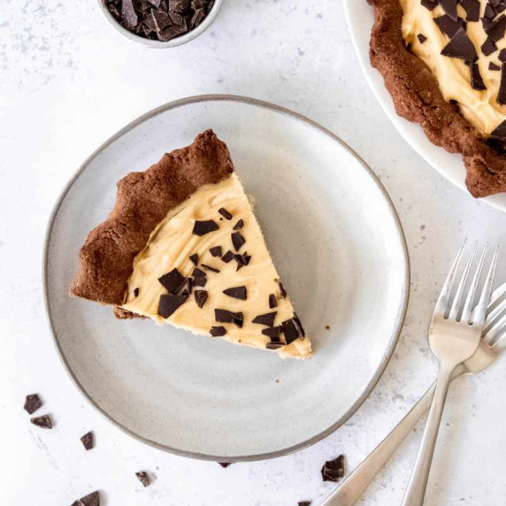 Overhead of a slice of peanut butter pie with chocolate crust topped with broken chocolate pieces.