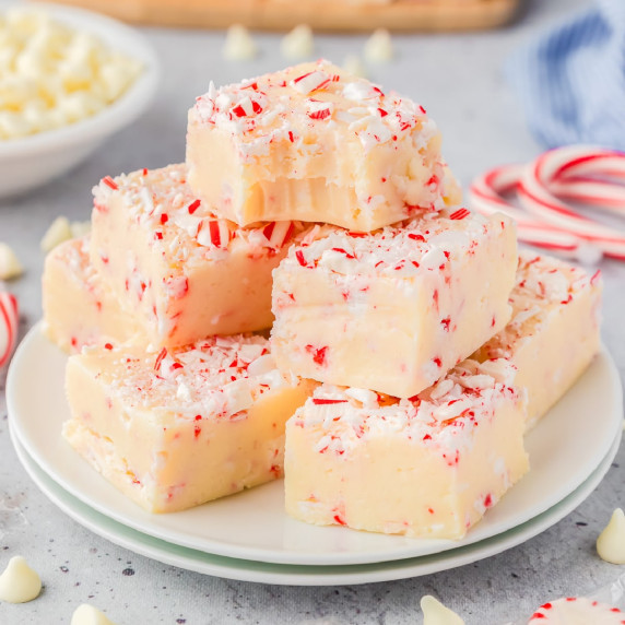 Peppermint fudge piled high on a plate topped with pieces of candy cane.