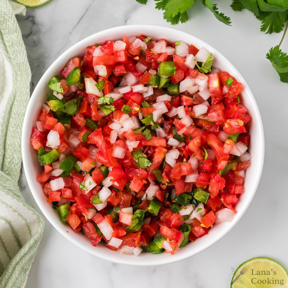 A white bowl filled with pico de gallo.