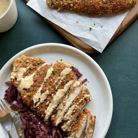 pretzel crusted chicken schnitzel is sliced and served