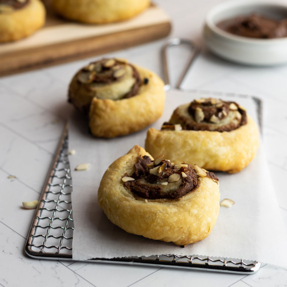 Puff pastry dessert with nutella and almonds on a wire rack