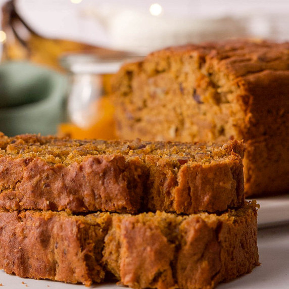 Pumpkin banana bread slices on counter with full loaf in the background