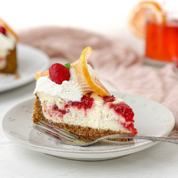 Slice of Raspberry Lemonade Cheesecake on a white plate.