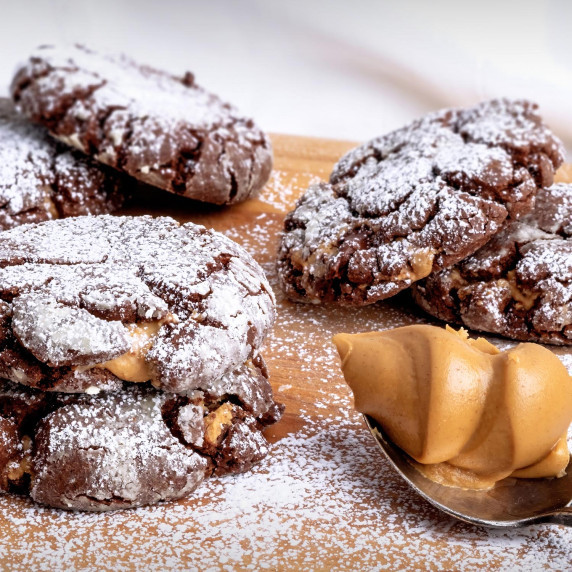Peanut Butter Stuffed Chocolate Crinkle Cookies on a cutting board.