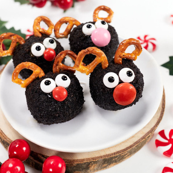 Oreo cookie balls shaped like reindeer with pretzel antlers.