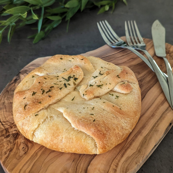 Baked brie en croute made with crescent roll dough, on a wooden serving board