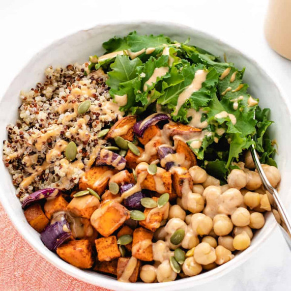 Roasted sweet potato nourish bowl with quinoa, chickpeas, and kale in a bowl.