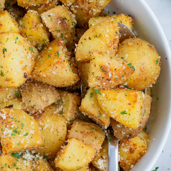 Roasted Yukon Gold Potatoes RECIPE served in a white bowl and spoon.