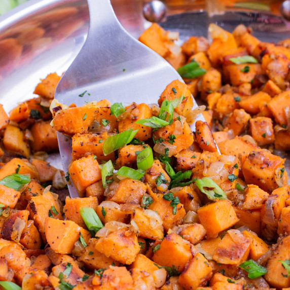 Skillet Sweet Potatoes with Cilantro RECIPE in the skillet with a spatula.