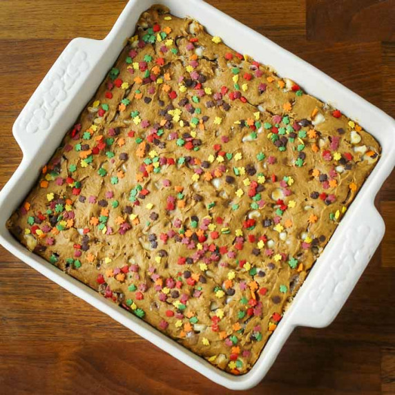 Overhead shot of spice cake with fall-themed sprinkles in a white square baking dish.