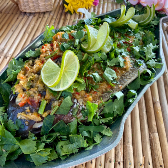 Thai steamed fish with lime and garlic in a fish-shaped dish.