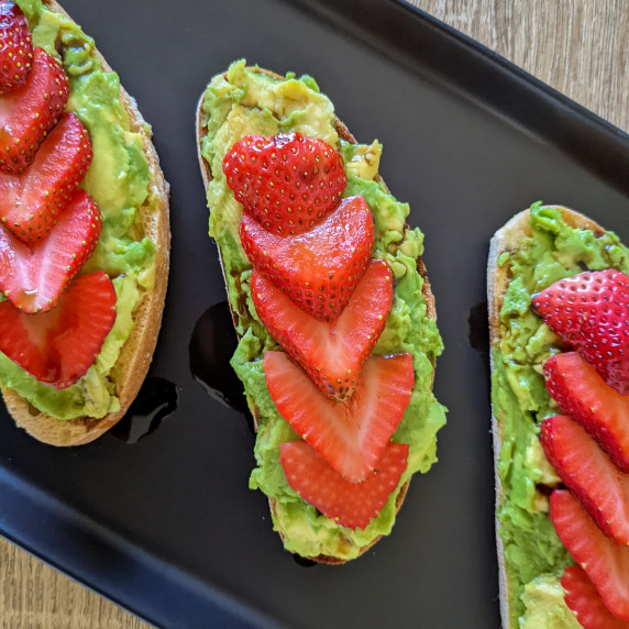 Avocado toast topped with fresh strawberry slices