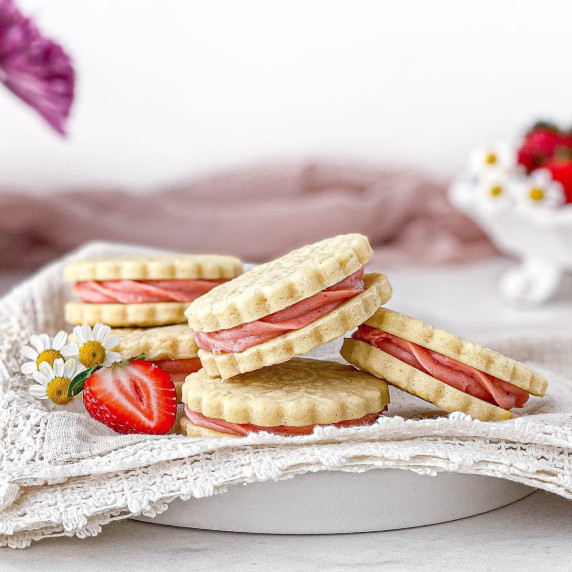 Strawberry Cheesecake Cookies stacked on a plate with a lace-trimmed napkin.