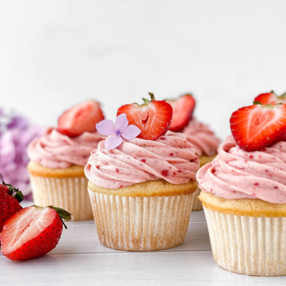 Strawberry Filled Cupcakes with fresh strawberries on top.