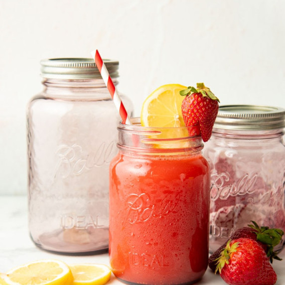 Homemade strawberry lemonade in a Ball Rose Vintage Pint Jar with two empty rose jars behind.