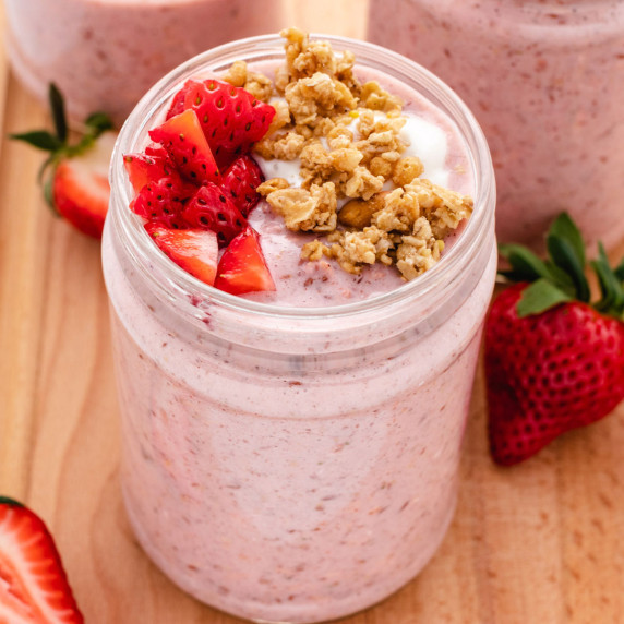 Strawberry overnight oats in a jar with diced strawberries and granola on top.