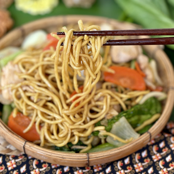Chicken egg noodle stir-fry in a bamboo dish.
