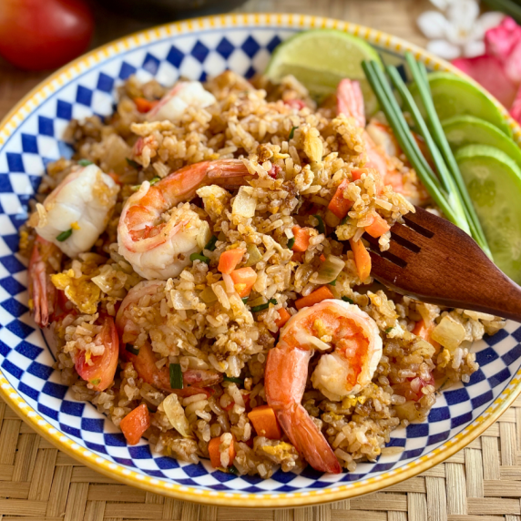 Thai shrimp fried rice with vegetables in a patterned dish.