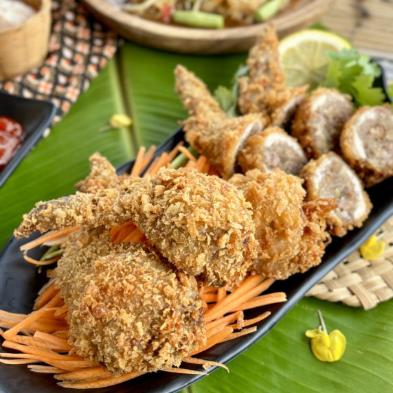 Thai stuffed chicken wings on a black dish.