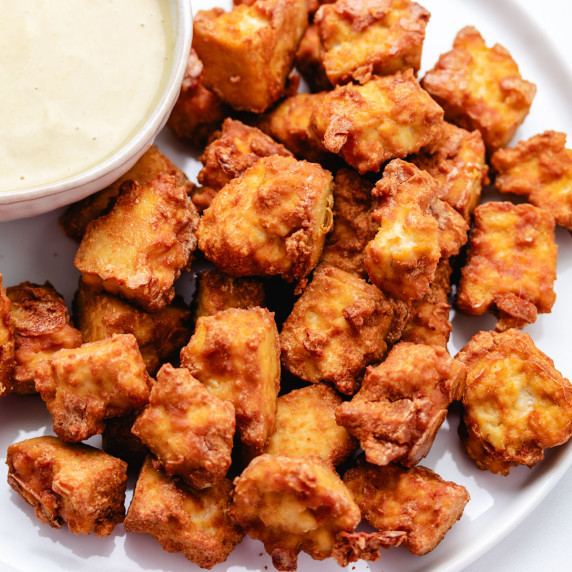 Baked tofu nuggets on a white plate.