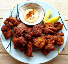 a plate with chicken karaage, lemon slices and mayo.