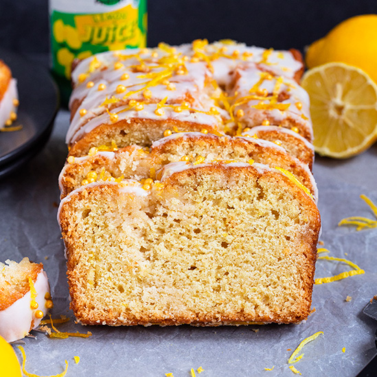 Vegan Lemon Drizzle Cake sliced and decorated with icing and lemon zest