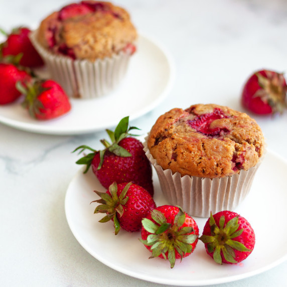 vegan strawberry muffin surrounded by fresh strawberries