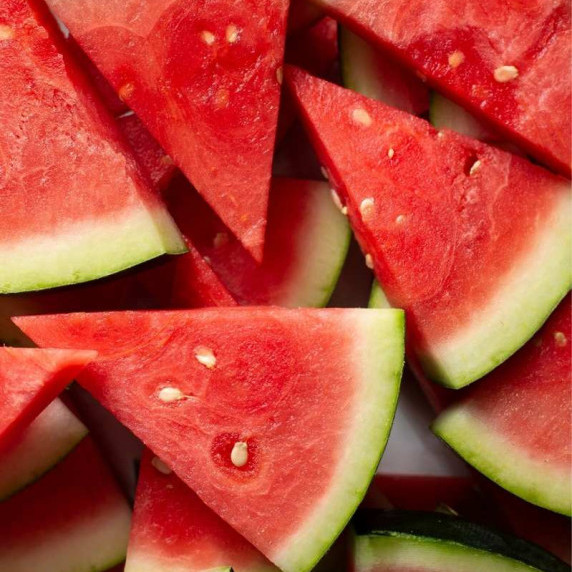 Wedges of watermelon cut into small triangles piled high on top of each other.