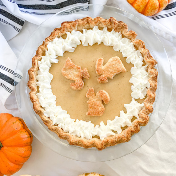 white pumpkin pie with pie crust squirrels and whipped cream
